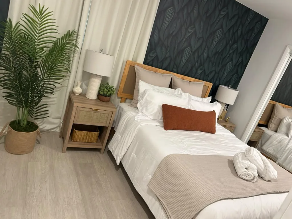 A turned-over Airbnb bedroom with a made bed and a welcome basket, cleaned by Sunset Sparkle