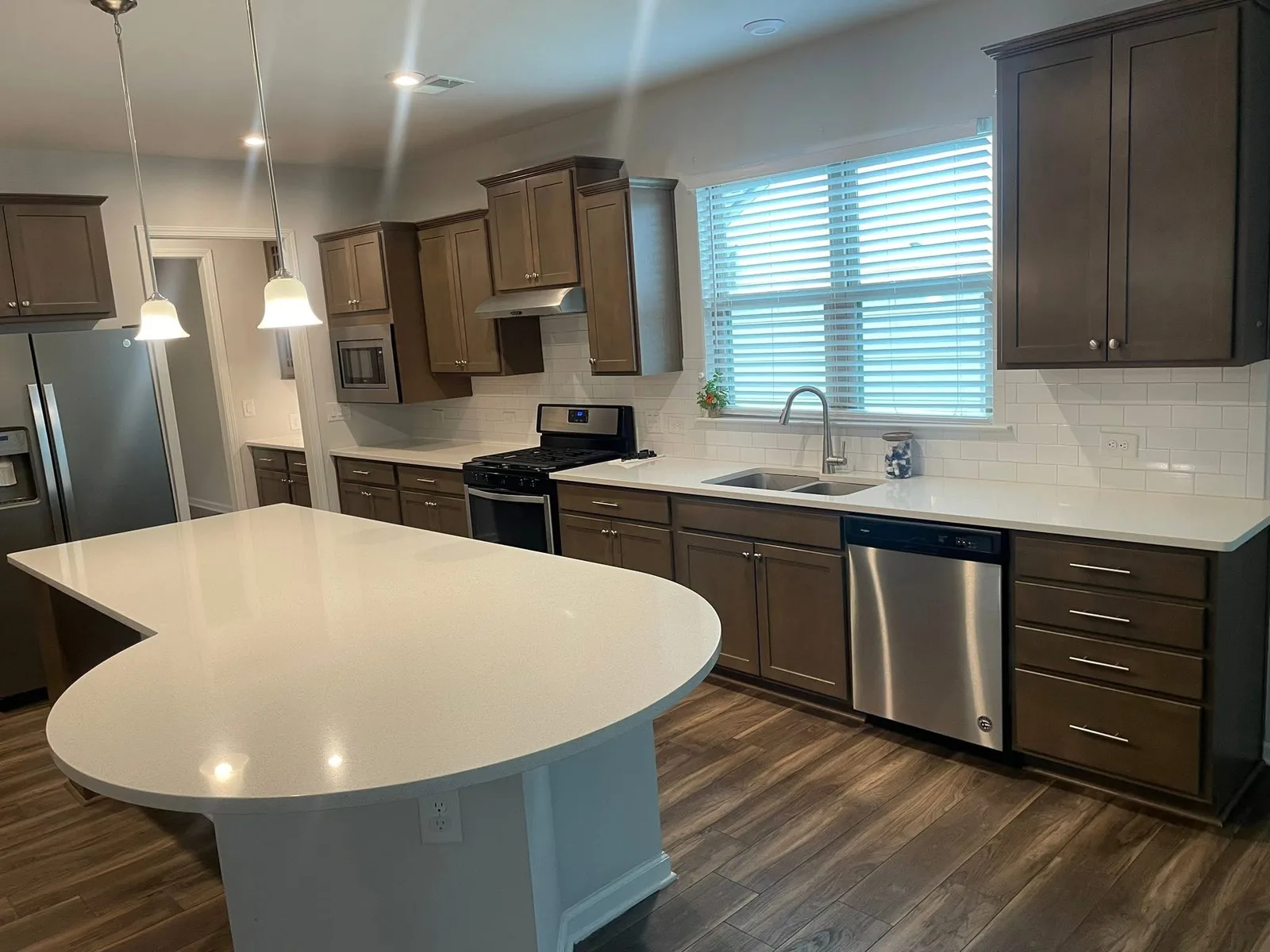 A move-in clean kitchen with a white island and wood floors
